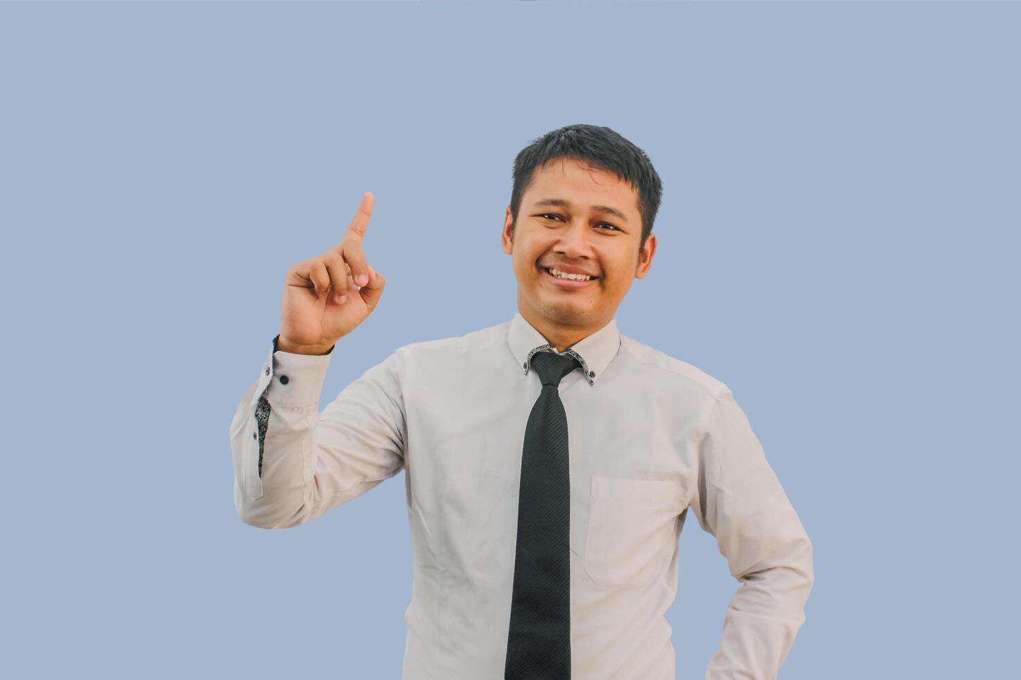 Javanese man smiling happy while pointing finger up photo