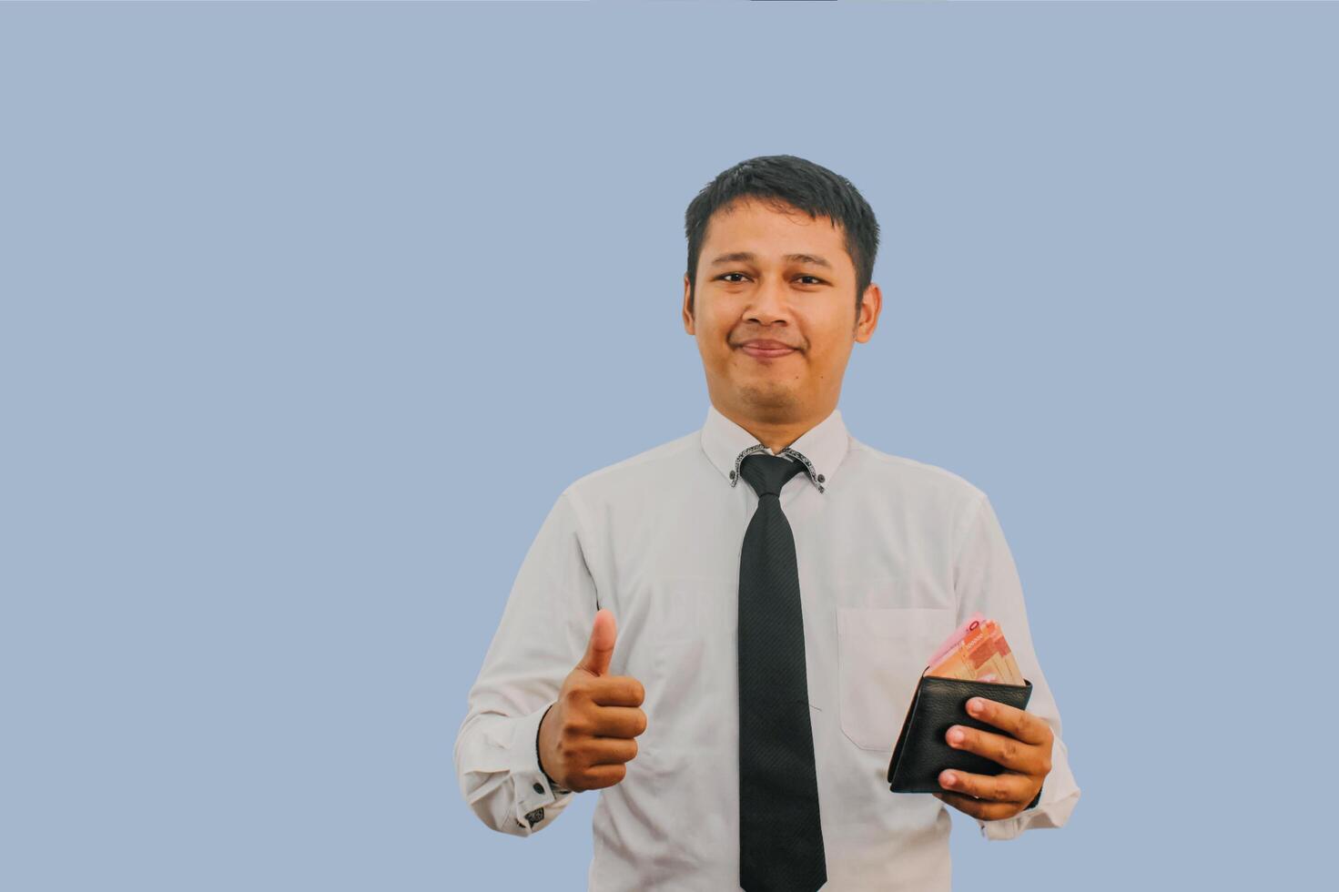 Adult Asian man smiling while holding wallet with money and give thumb finger sign photo