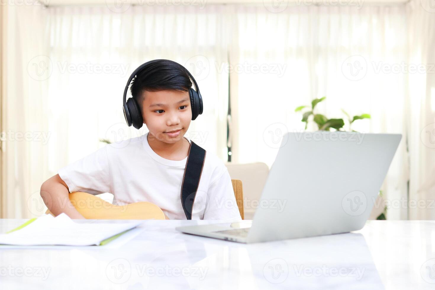 asiático chico vistiendo negro auriculares aprender música en línea a hogar. concepto de en línea educación mediante el Internet. moderno aprendizaje foto