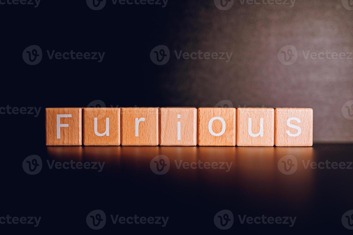 Wooden blocks form the text Furious against a black background. photo