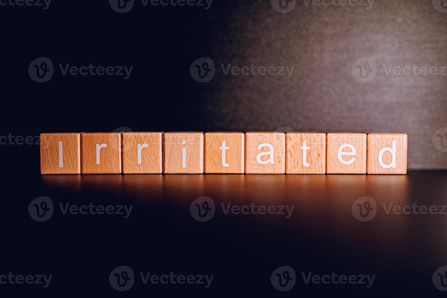 Wooden blocks form the text Irritated against a black background. photo