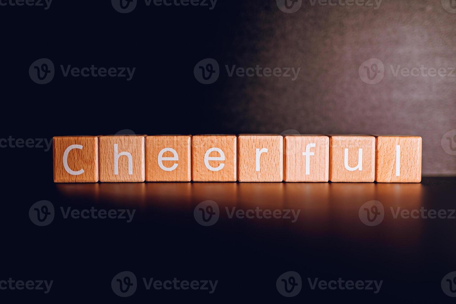 Wooden blocks form the text Cheerful against a black background. photo