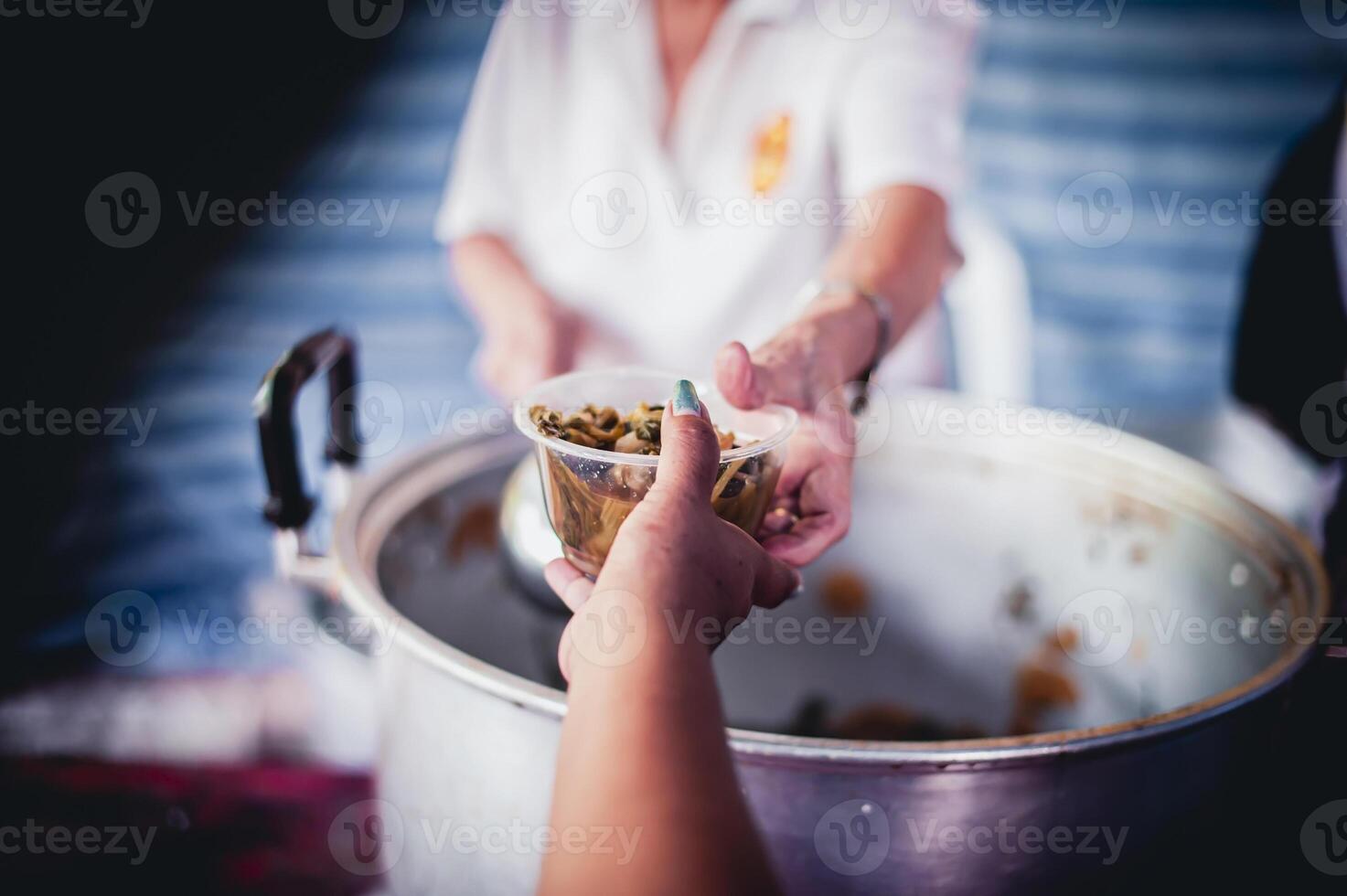 The hands of the poor apply for food from rich people who donate food. photo