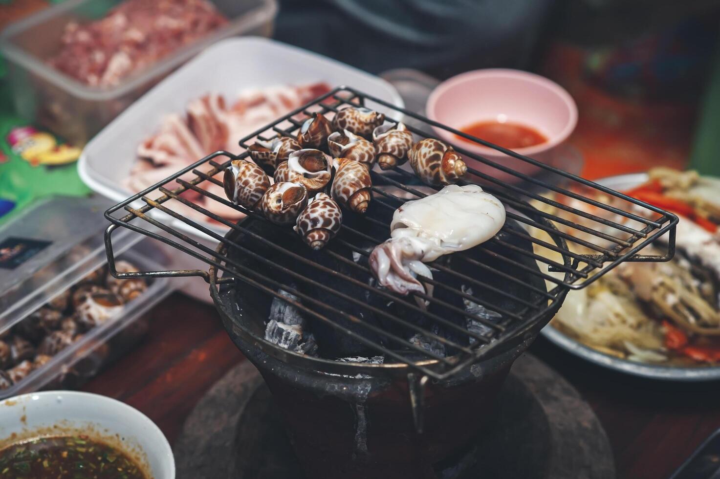 Sweet clams are grilled on a charcoal grill over low heat. photo