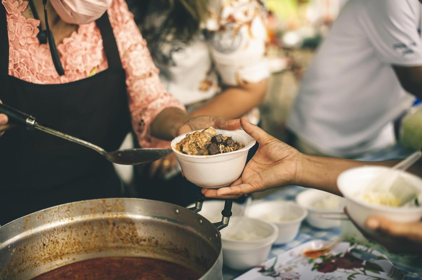 Hands of poor people asking for food from volunteers helping concept of food donation photo