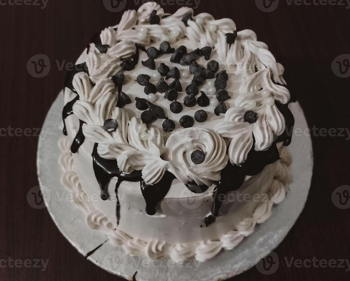 delicioso cumpleaños pastel con blanco crema y chocolate en de madera mesa parte superior ver - dulce postre foto