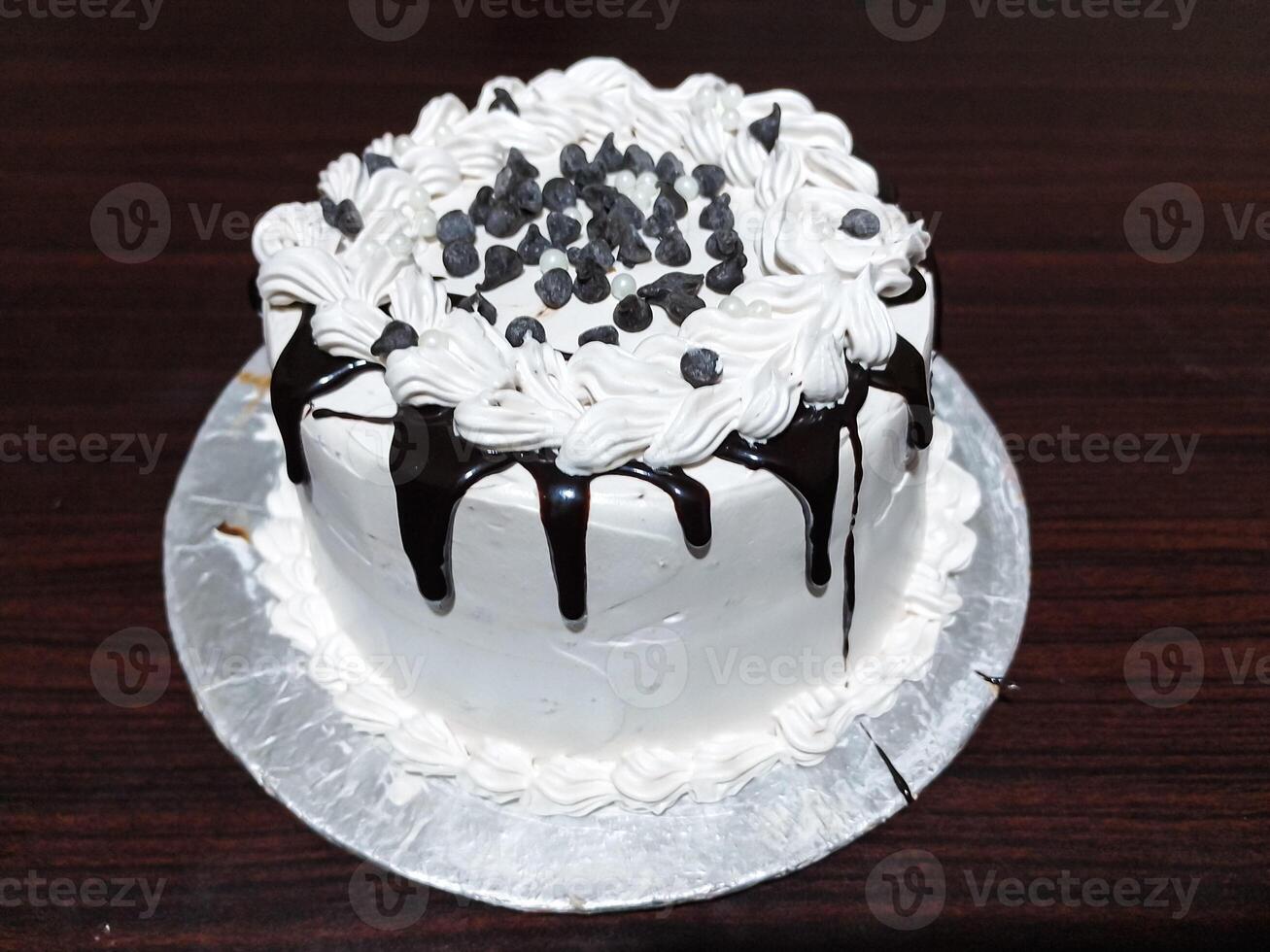 Delicious Birthday Cake with White Cream and Chocolate on wooden table top View - Sweet Dessert photo