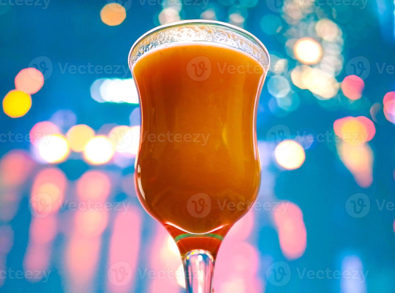 naranja jugo en bar vaso en frente de borroso parpadeo luces antecedentes foto