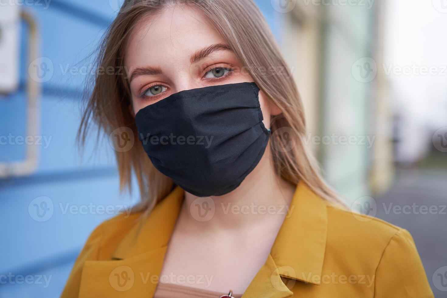 Young Caucasian European girl 20 years old wearing black protective medical mask protection against epidemic coronavirus covid-19 photo