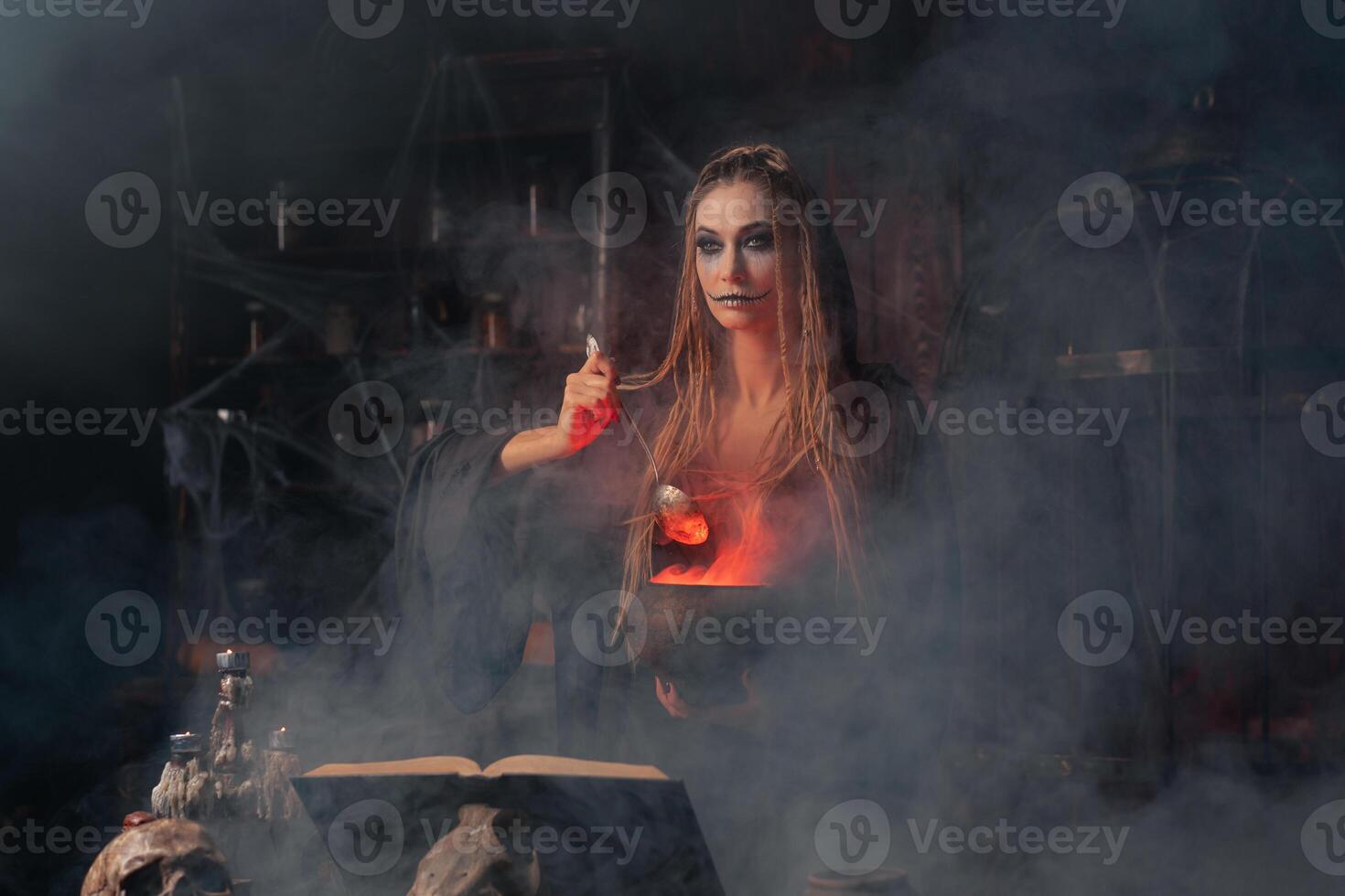 Víspera de Todos los Santos, bruja utilizar magia libro y caldera preparar veneno o amor poción foto