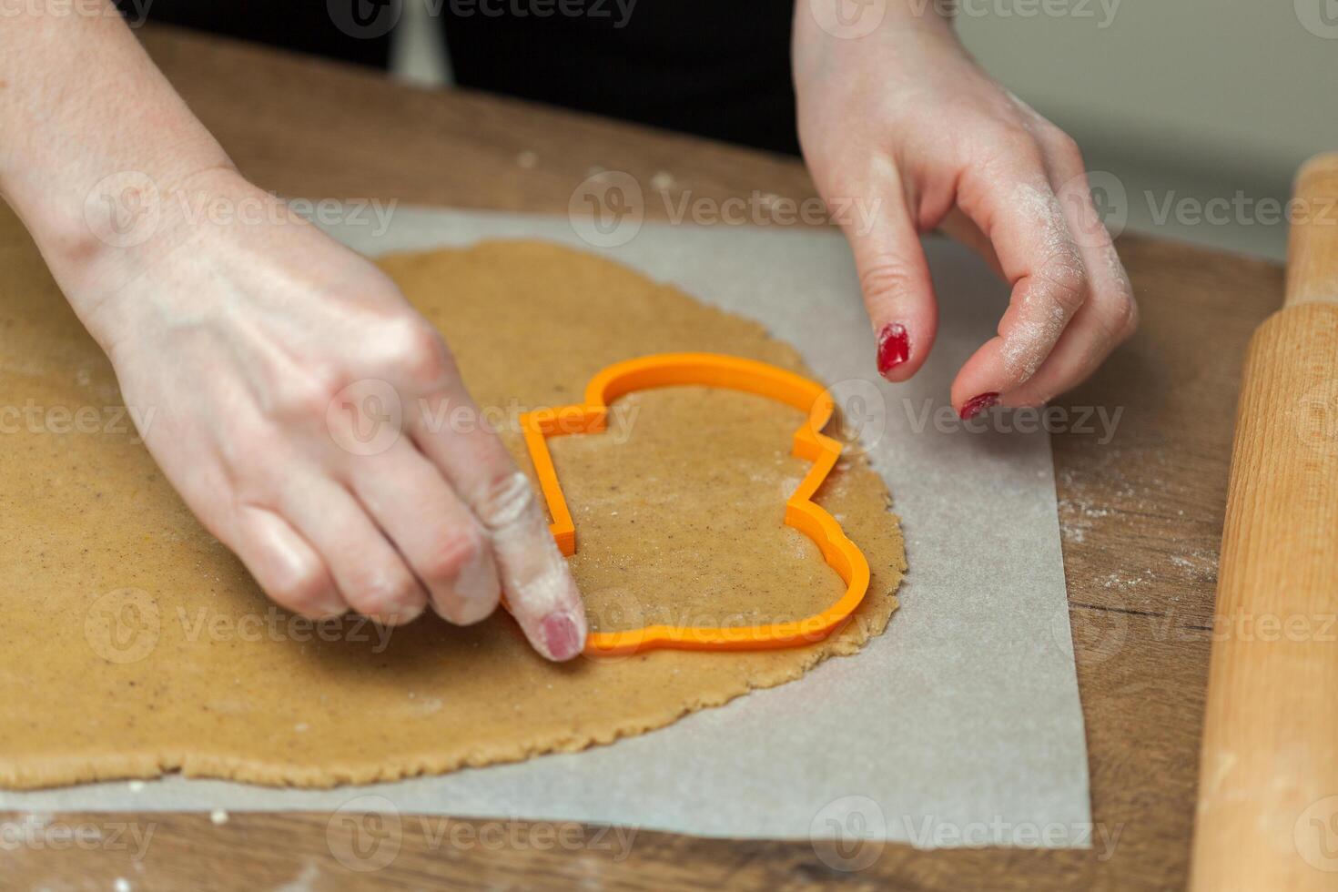 close up of female hands making cookies from fresh dough at home photo