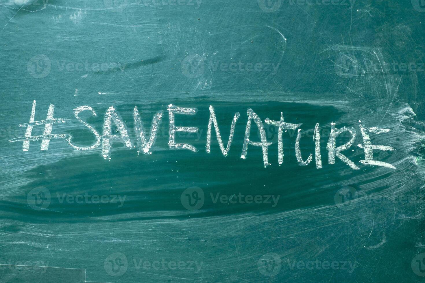 Save the nature hashtag it handwritten with white chalk on a green blackboard photo