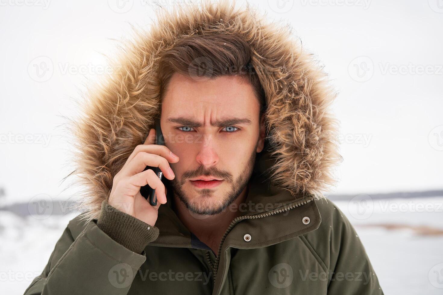 Attractive bearded man standing outdoors in winter season forest. photo