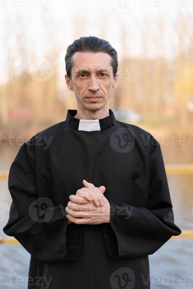 Portrait of handsome catholic priest or pastor with collar photo