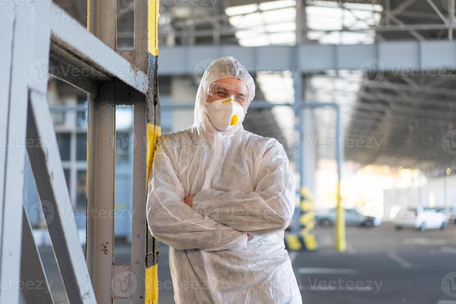 COVID-19 coronavirus doctor standing hospital parking dressed white protective overalls hazmat suit. photo