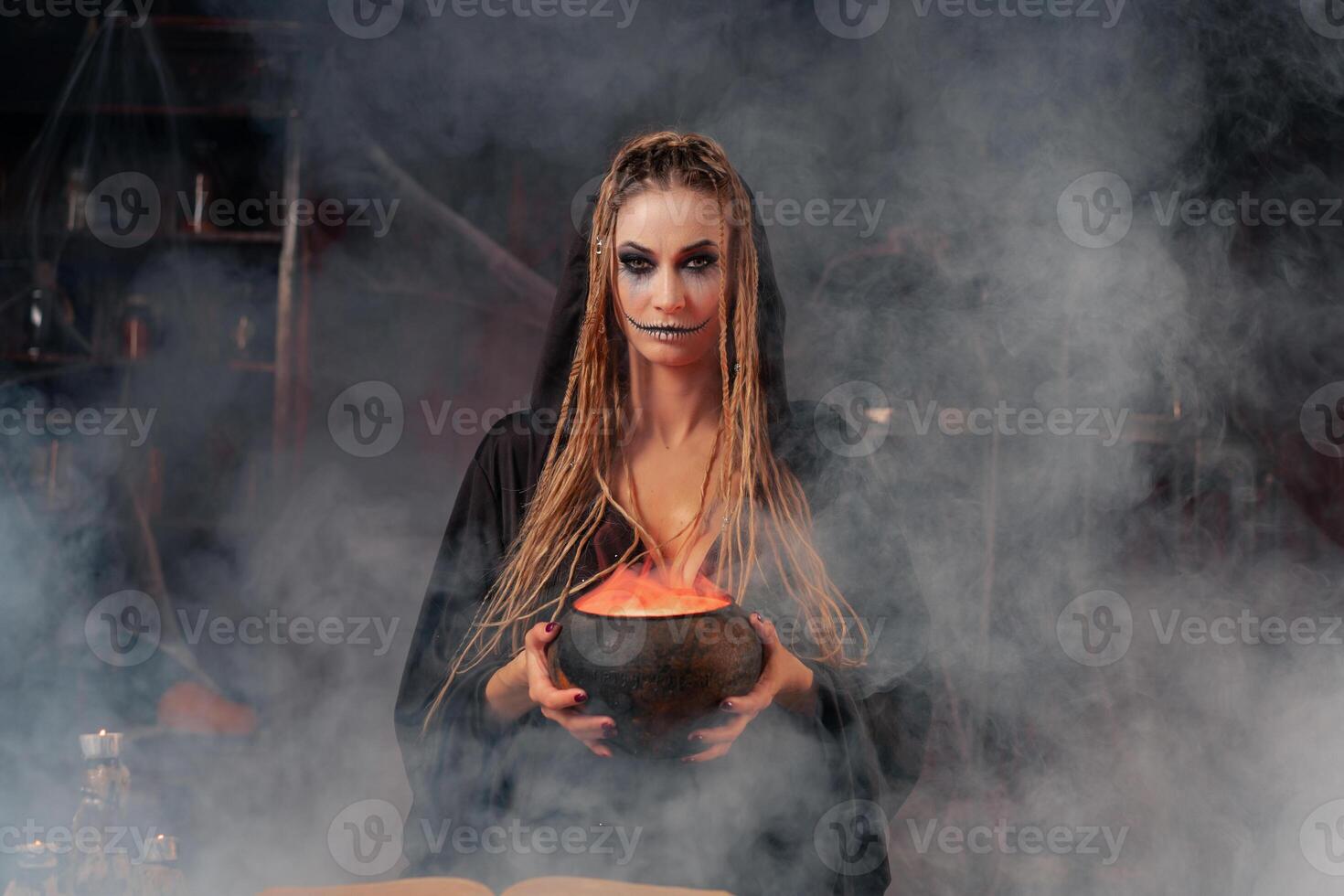 Halloween, witch use magic book and cauldron prepare poison or love potion photo