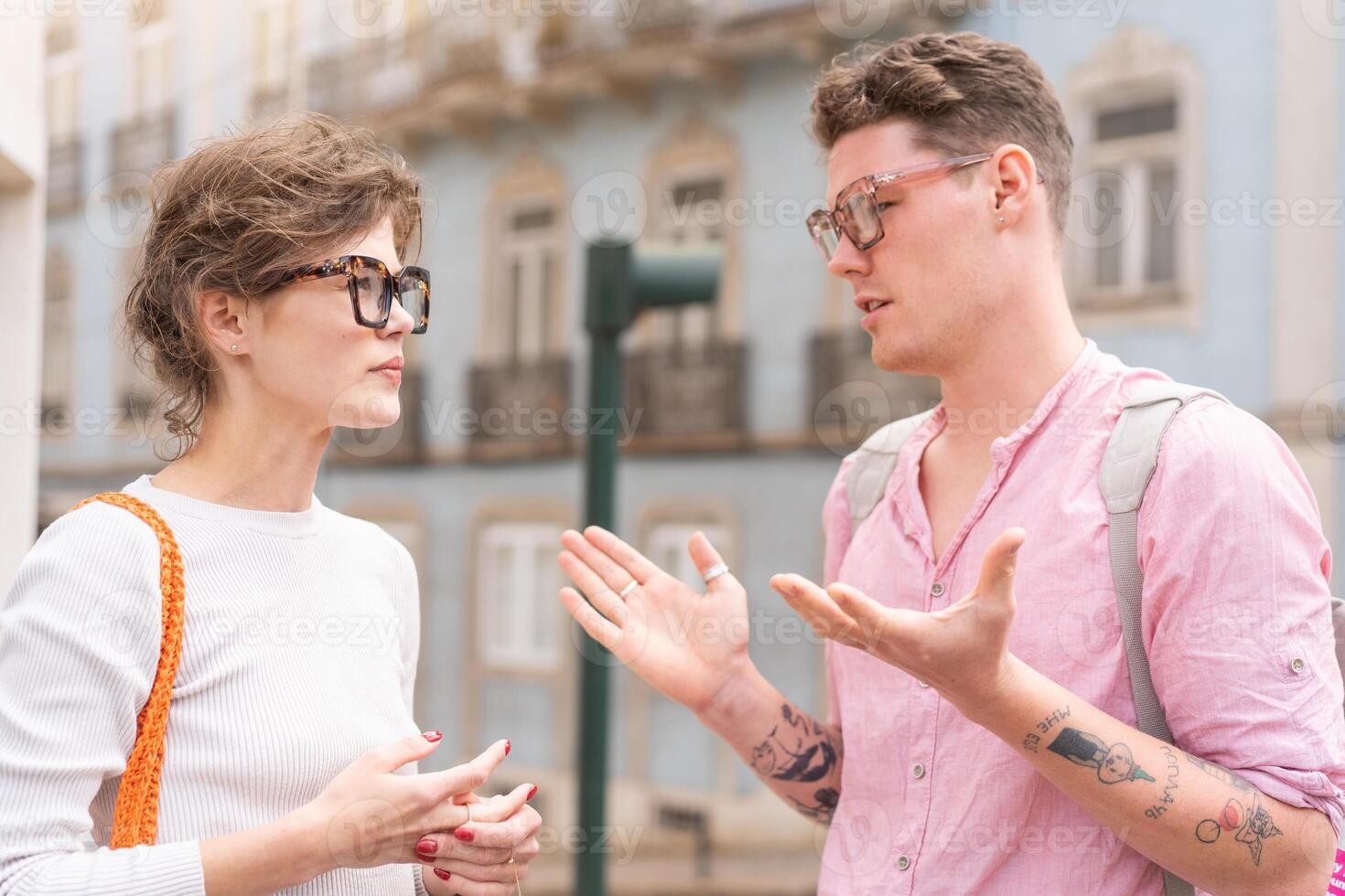 Young beautiful hipster couple in sunglasses in love walking on old city street photo