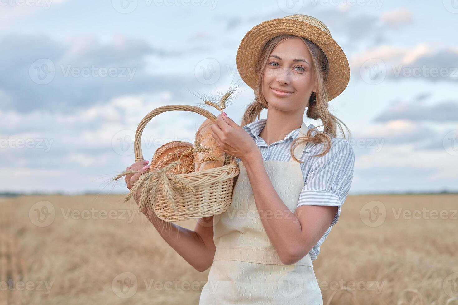 Female farmer standing wheat agricultural field Woman baker holding wicker basket bread product photo