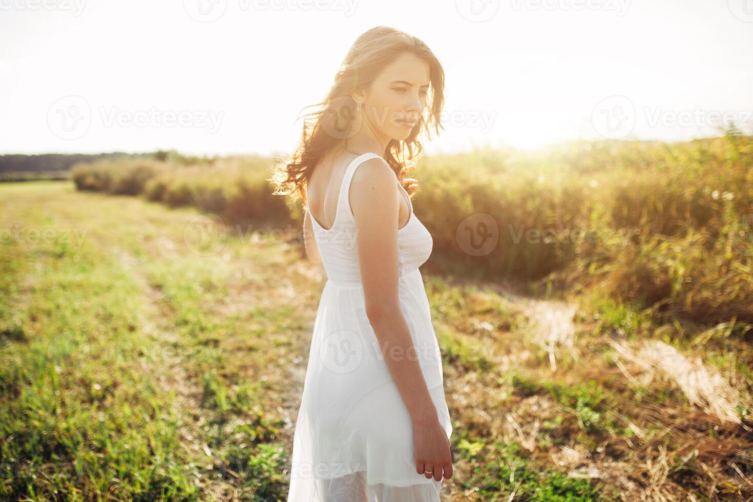 Beautiful caucasian girl walking on the field. Summer time day photo