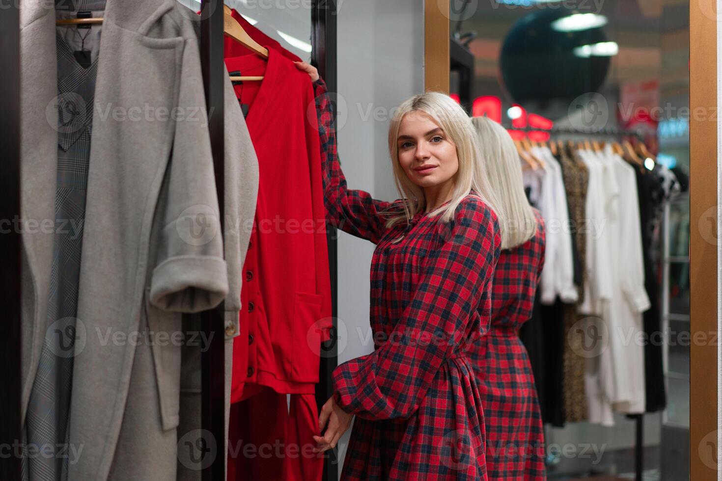 One caucasian women in a fashion boutique choose clothes buy for autumn season. photo