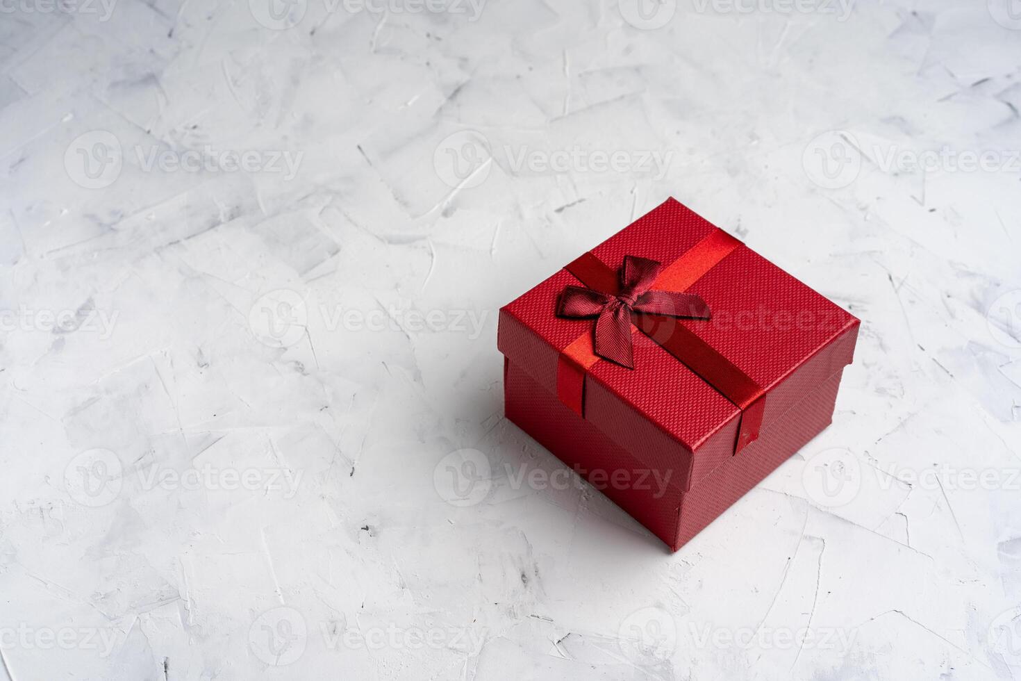 Red square holiday gift box against a white  background photo