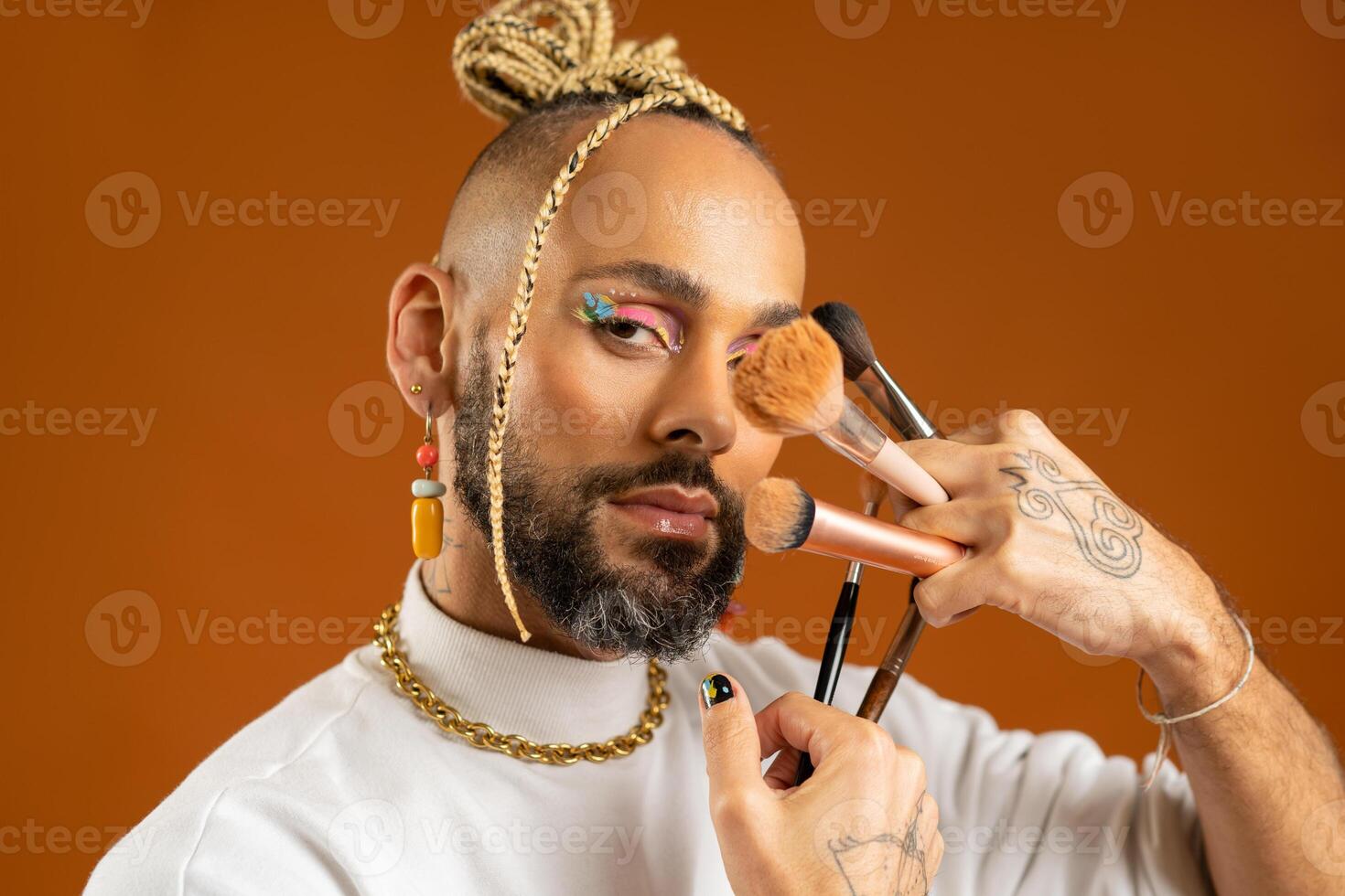 African american gay applying make up isolated on orange background photo