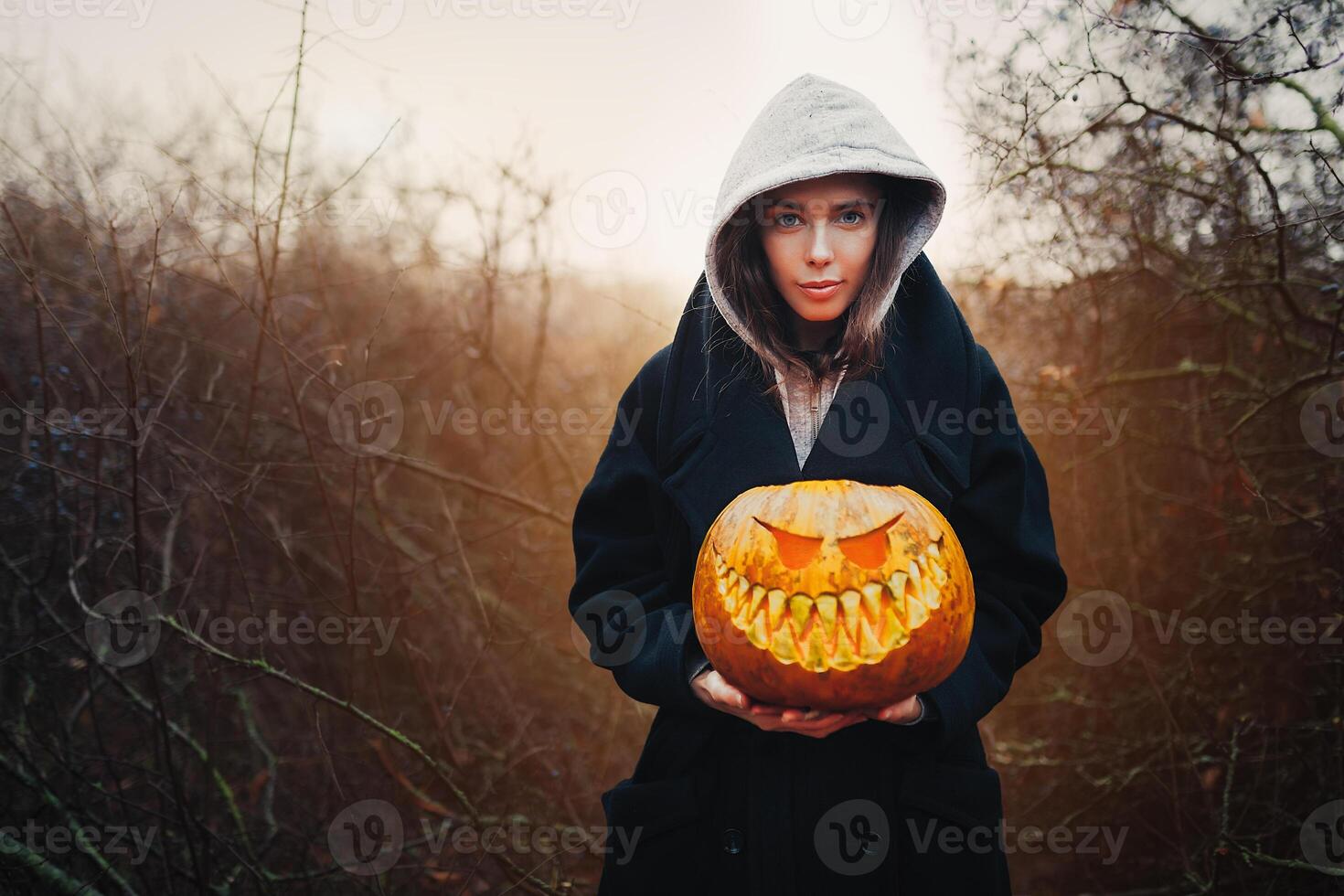 Young smiling woman holding the halloween pumpkin photo