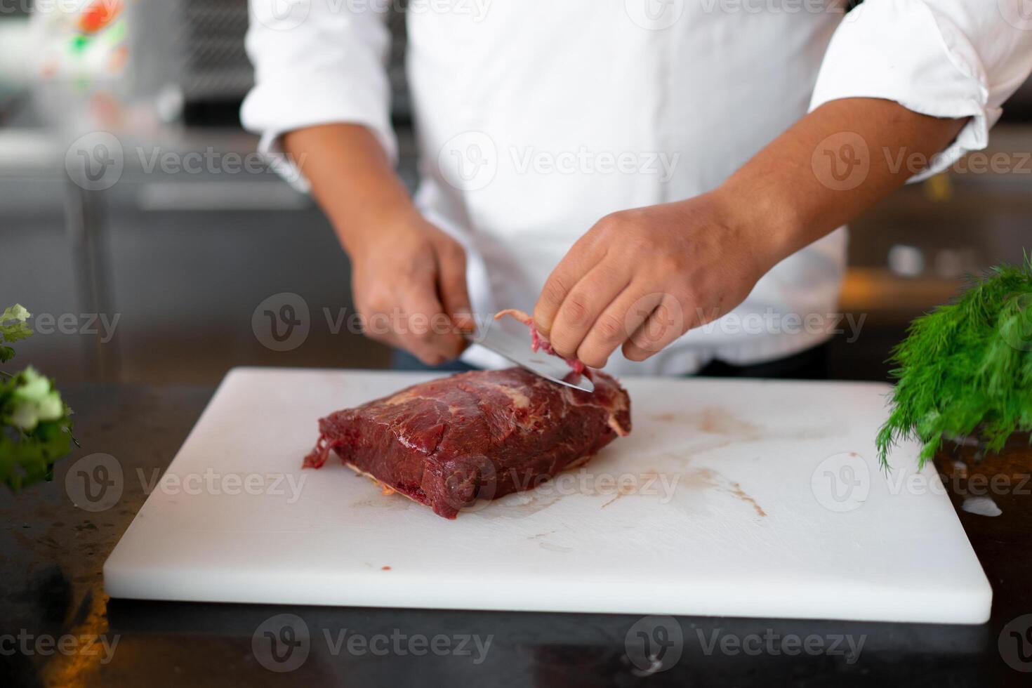 unrecognizable young African chef standing in professional kitchen in restaurant preparing a meal of meat and cheese vegetables. photo