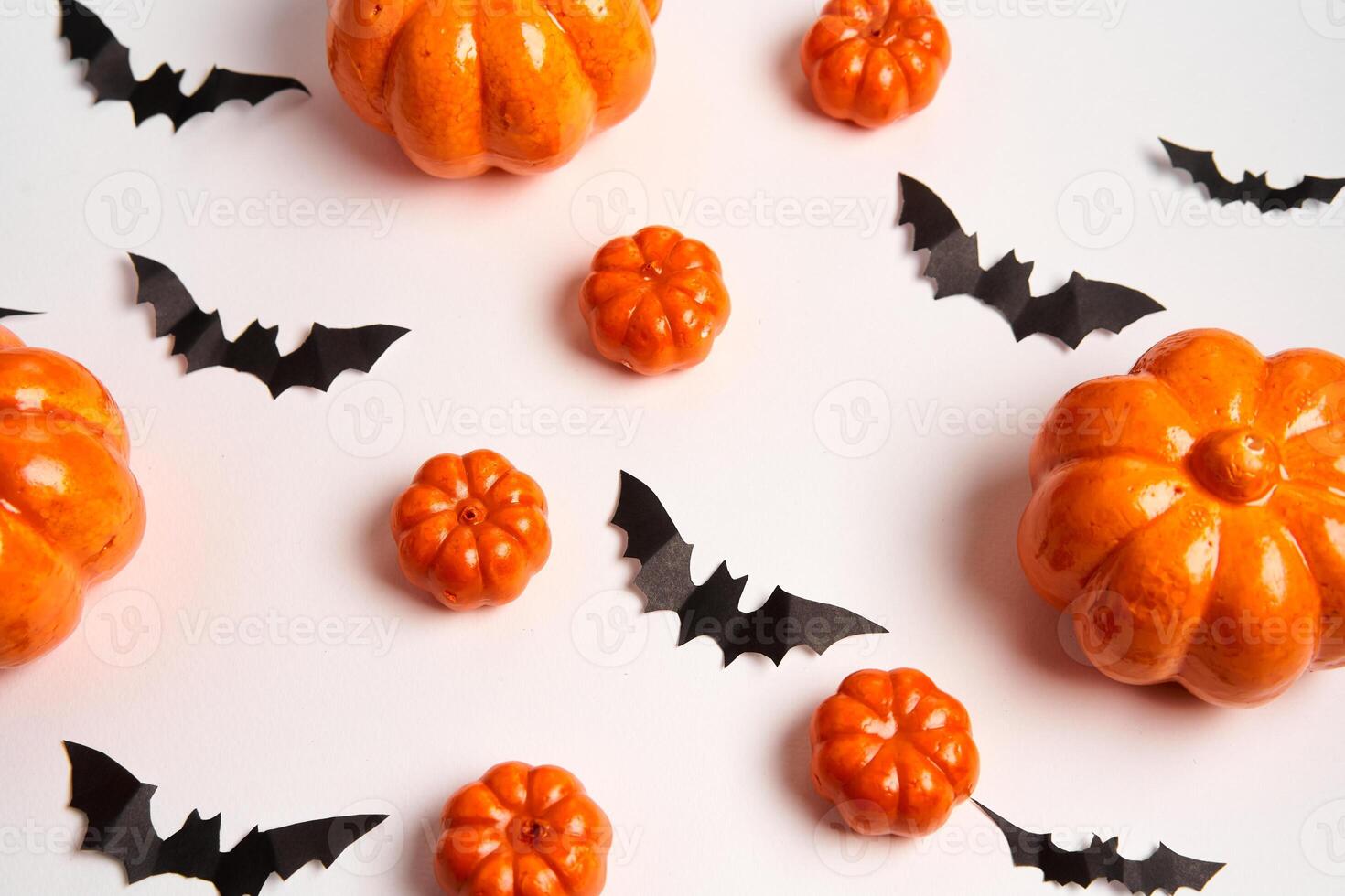 Halloween background, orange decorative plastic pumpkin black paper bat white cardboard Thanksgiving greeting card photo