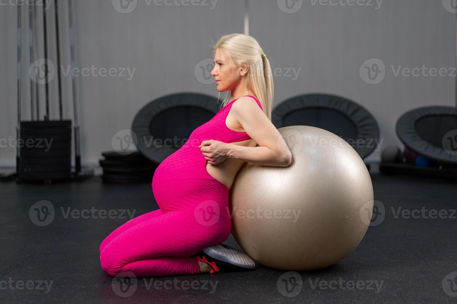 Pregnant woman exercise with fitness bal in gym photo