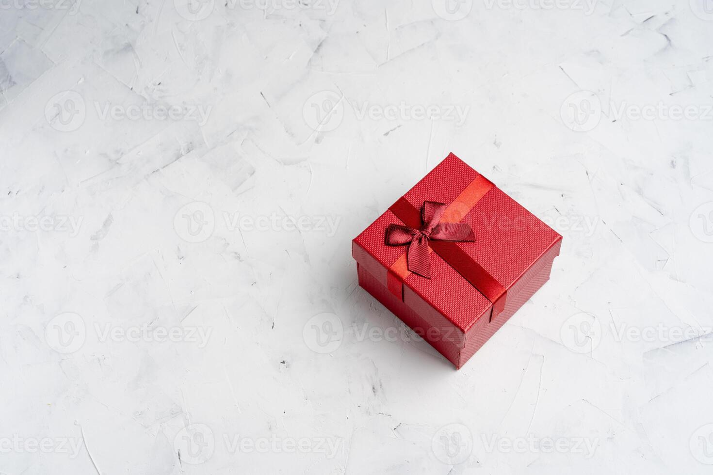 Red square holiday gift box against a white  background photo