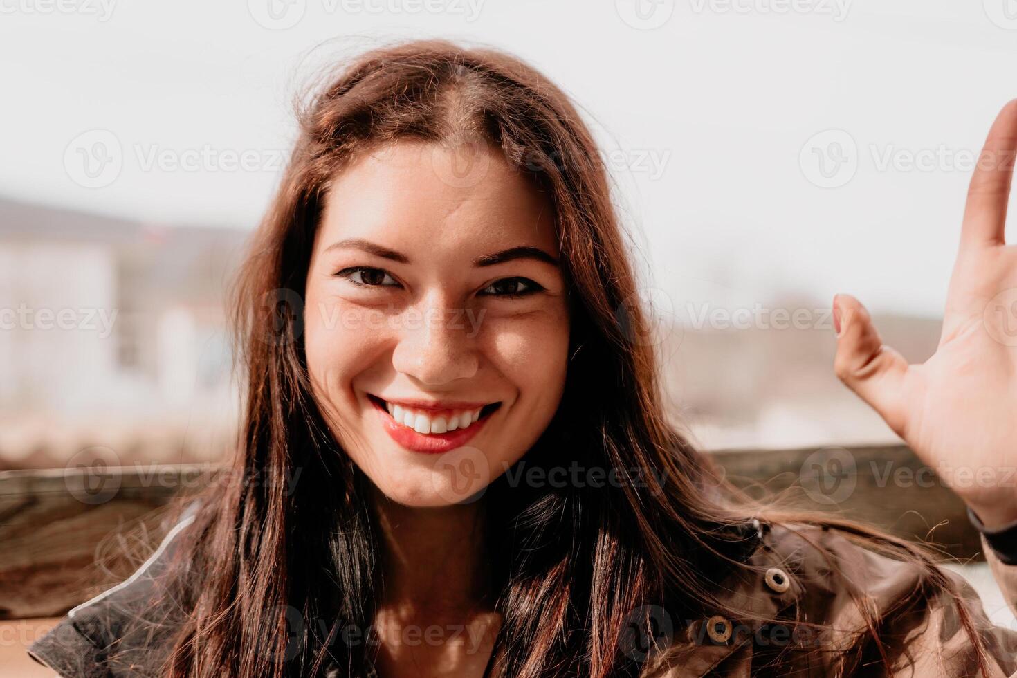 contento joven sonriente mujer con pecas al aire libre retrato. suave soleado colores. al aire libre de cerca retrato de un joven morena mujer y mirando a el cámara, posando en contra otoño naturaleza antecedentes foto