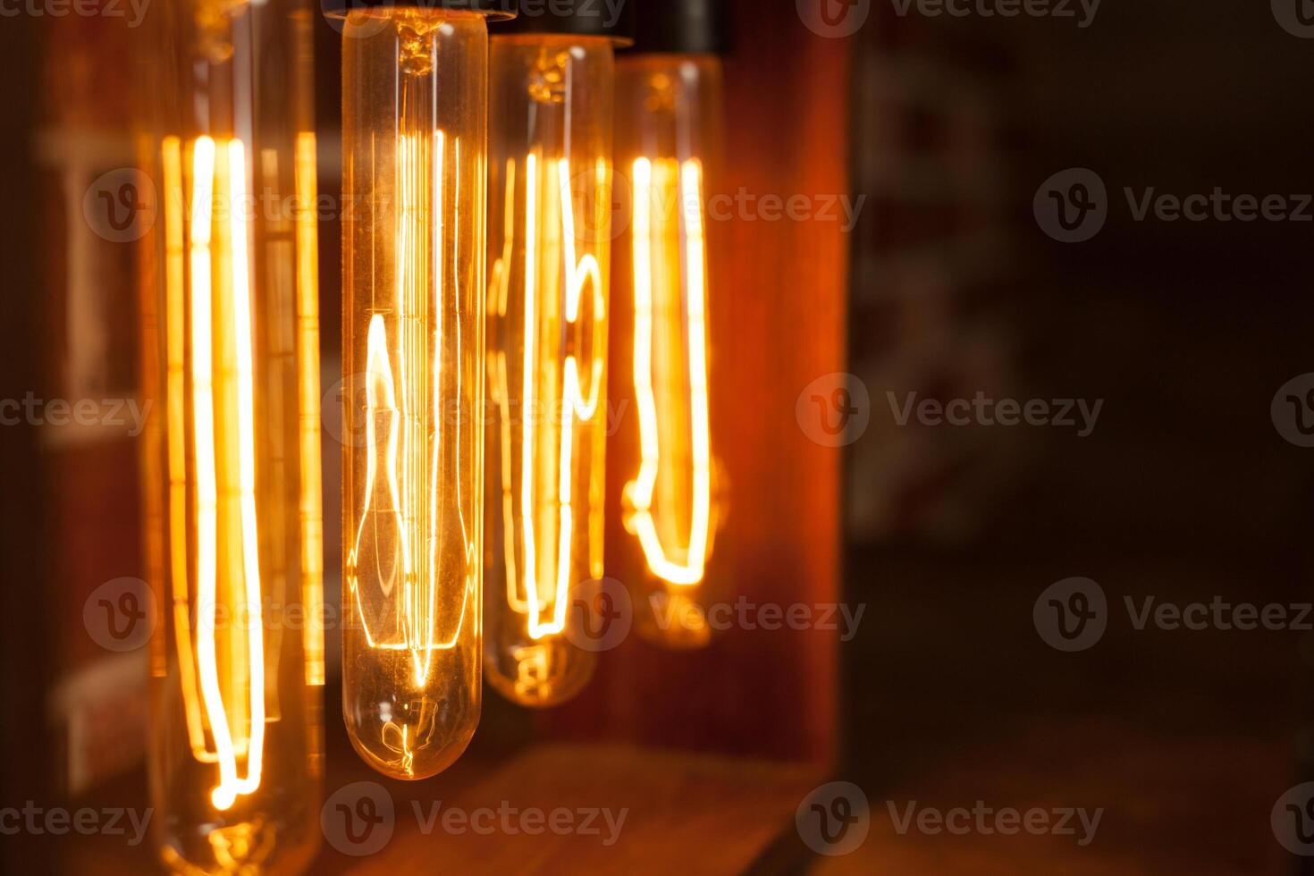 Light bulb lamp on dark red brick background with hotspot close up loft photo