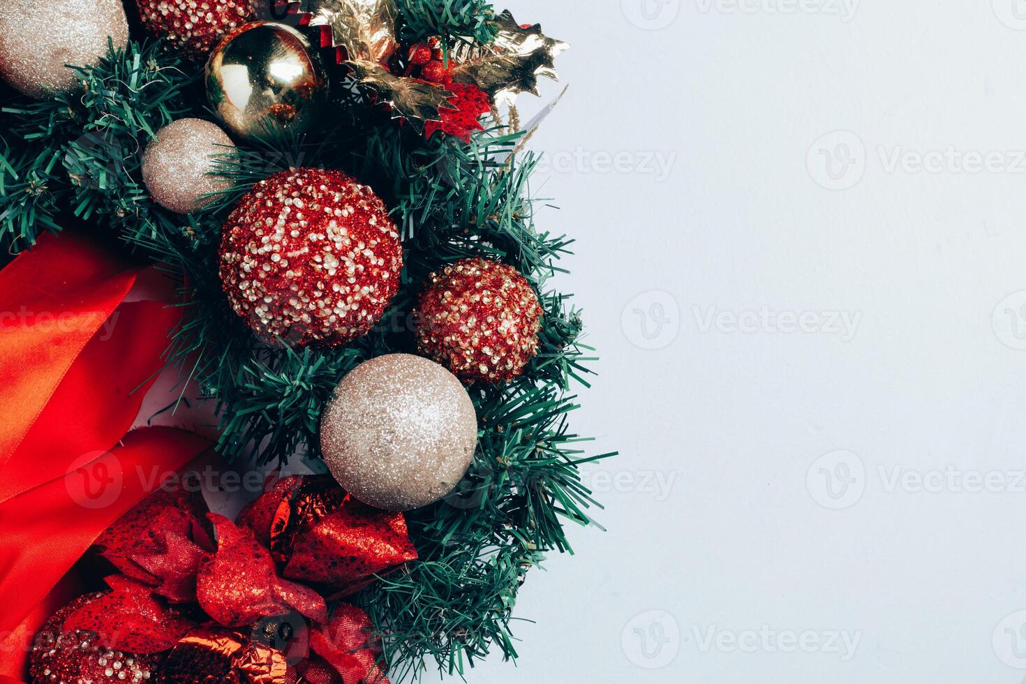 Christmas decorative wreath of holly, ivy, mistletoe, cedar and leyland leaf sprigs with red berries over white background. photo