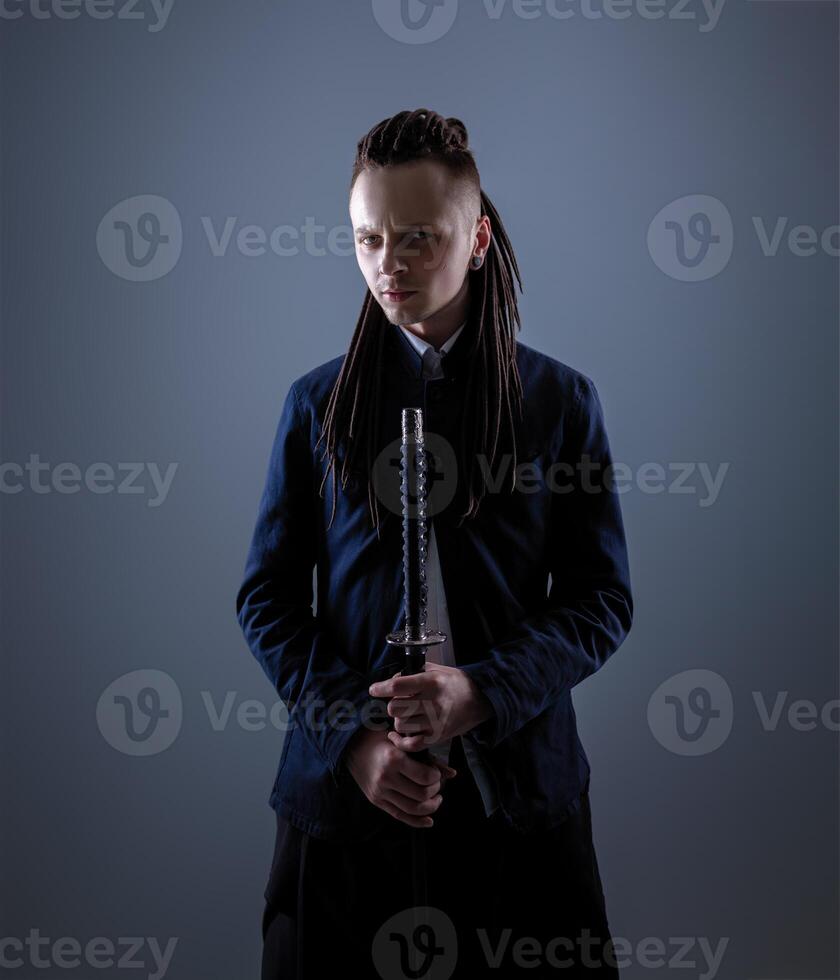 Young man holding a samurai sword. Glamour photo. photo