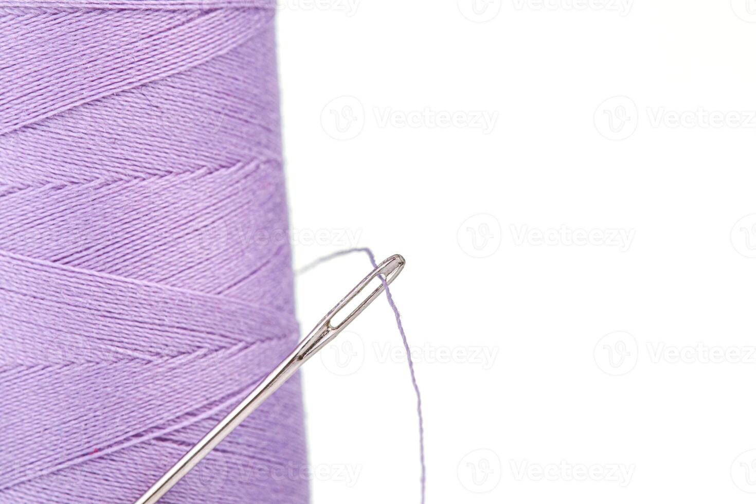 Macro skein of thread purple colors with a needle on a white background photo