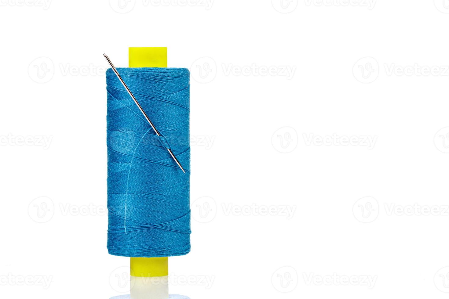 Macro skein of blue thread with a needle on a white background photo