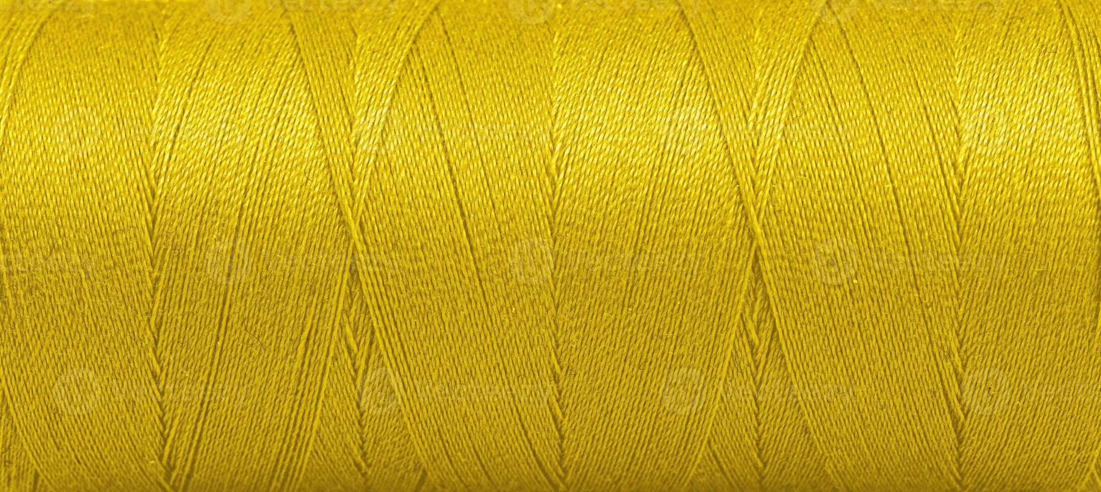 textura de hilos en un carrete de amarillo color en un blanco antecedentes foto