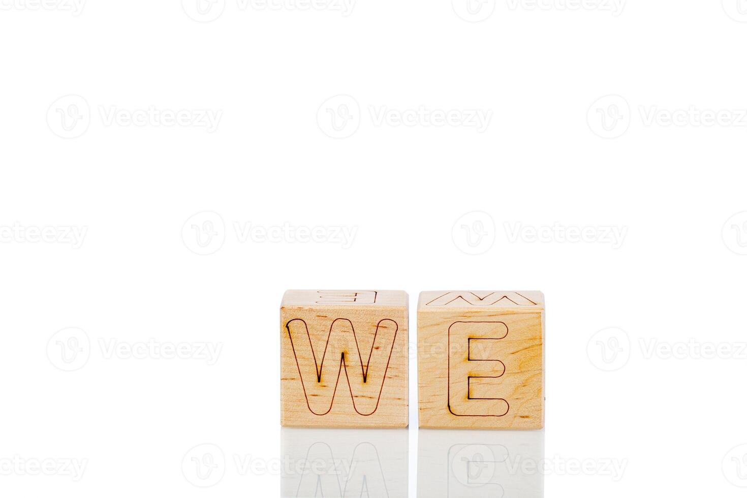 Wooden cubes with letters we on a white background photo