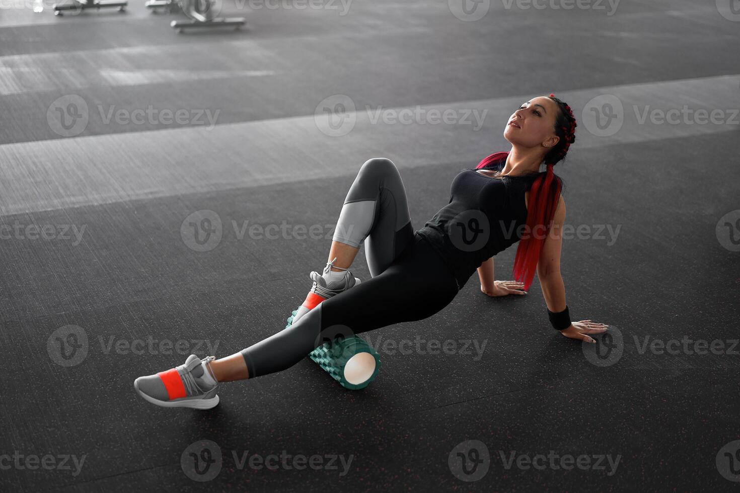 Woman massaging foam roll leg gym myofascial release exercise rolling