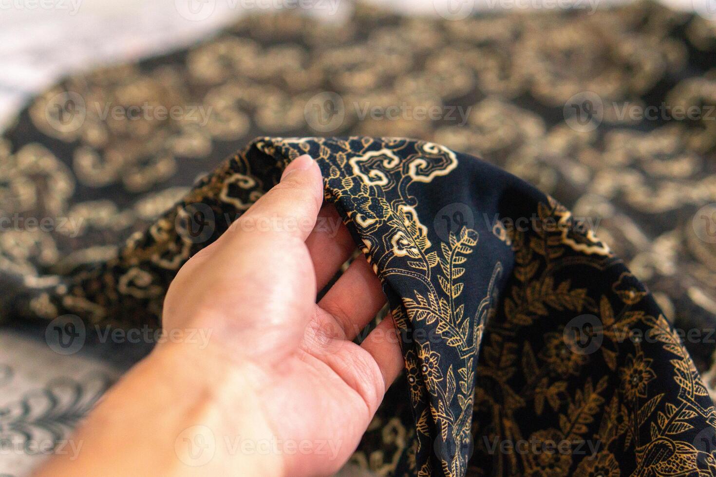 un mano participación tradicional indonesio tela, a saber batik paño. Indonesia con elegante clásico motivo foto