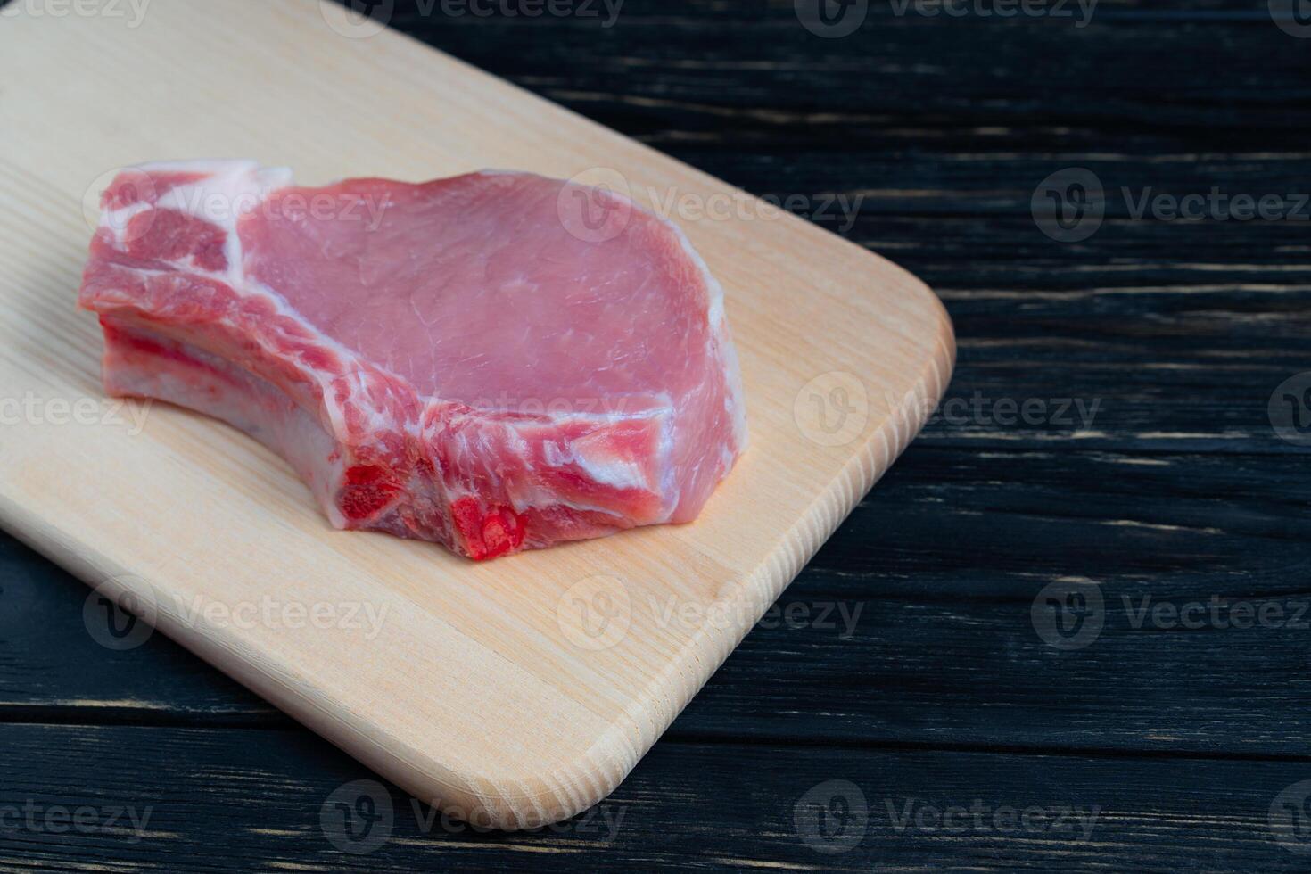 Top view of one pieces raw pork chop steaks on a cutting board. photo