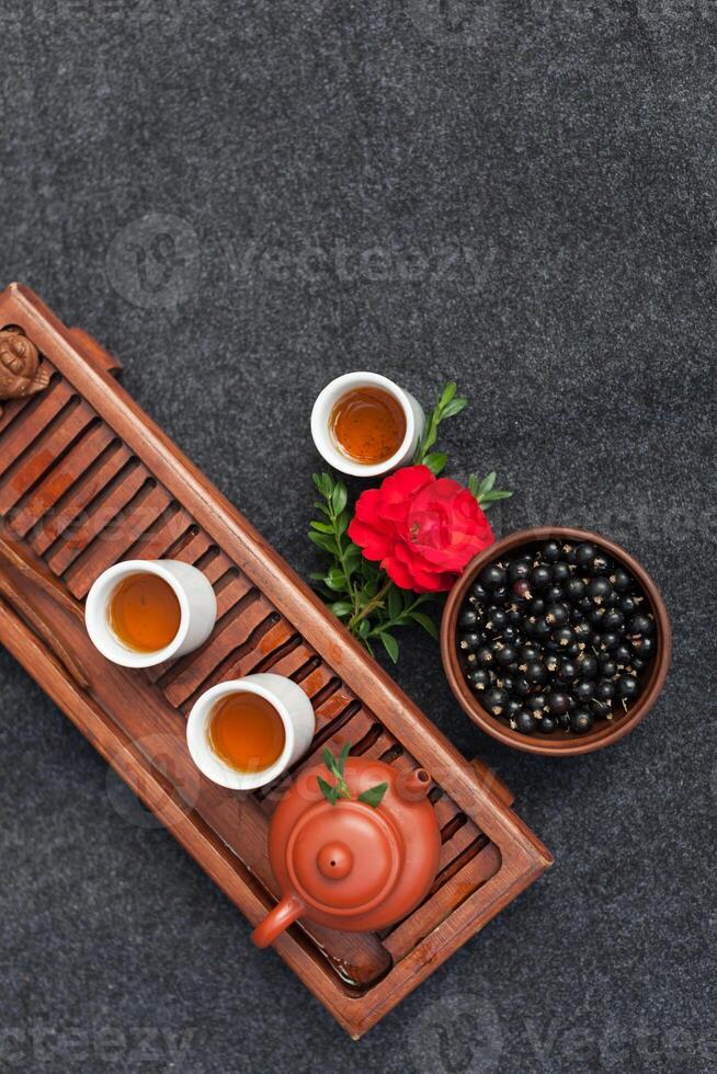 Traditional Chinese tea ceremony with black currant, fruit tea and healthy food. Photo without people. Summer natural vitamins and berries