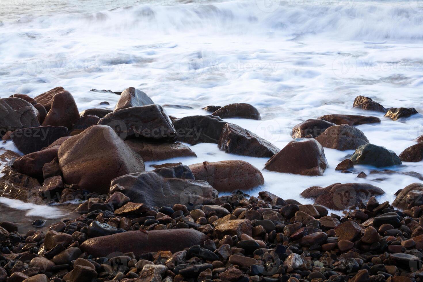 round stone in the sea or ocean foam wave photo