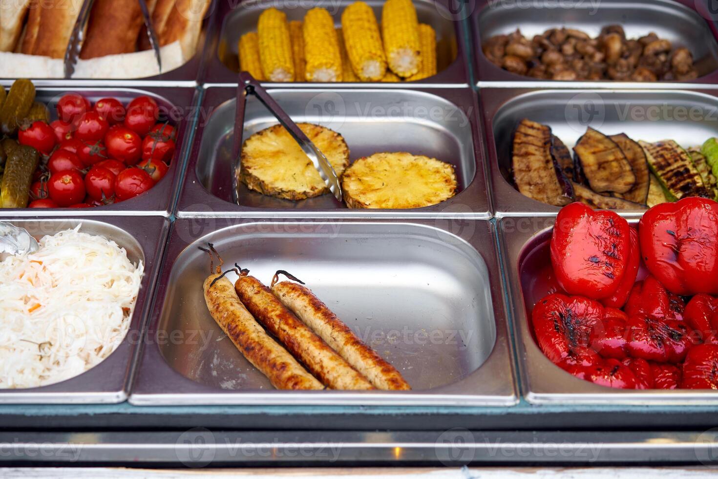 Street food grilled tomato, sausages, pineapple, sauerkraut, pepper, vegetable, corn, showcase market photo