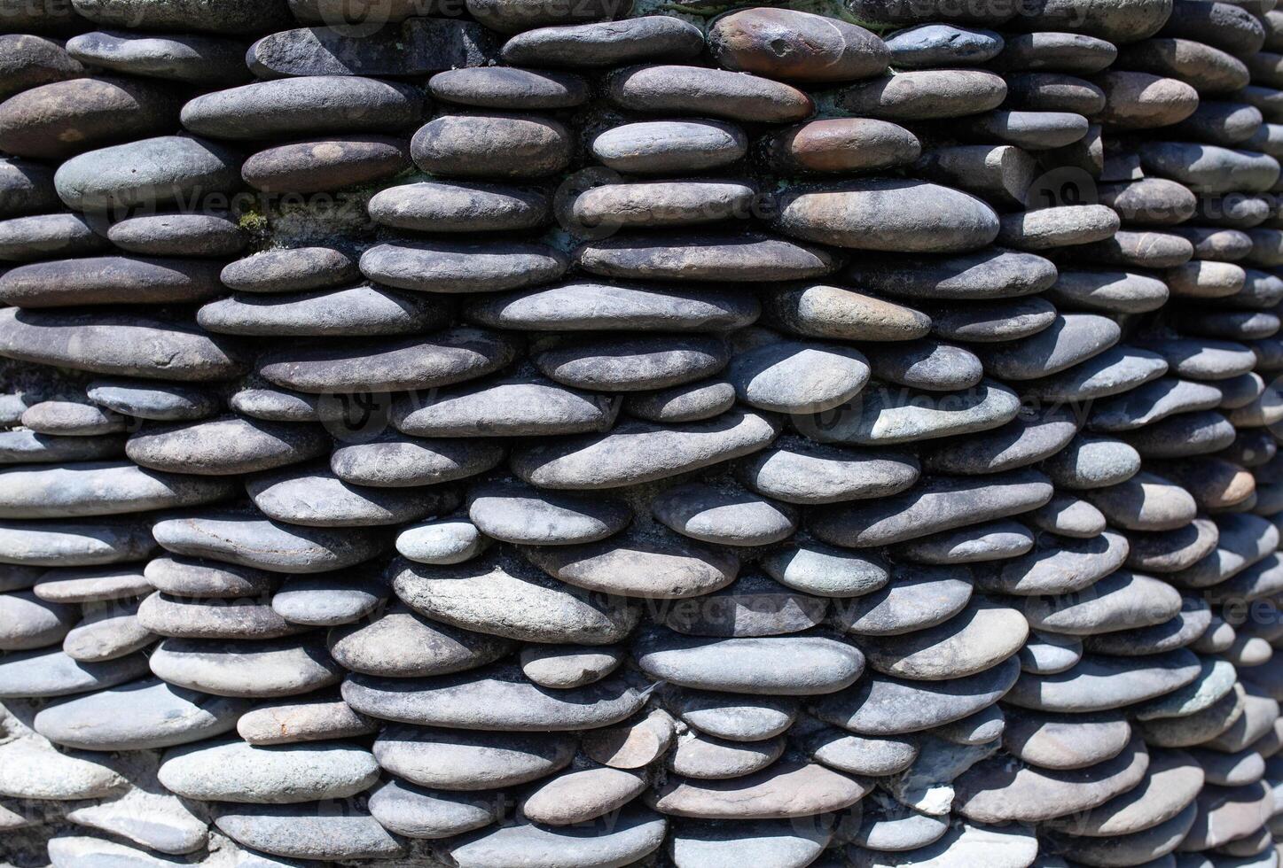 River pebble gravel round stone wall patterned for background. Gray pebbles background for home and home exterior wall and floor decoration. photo