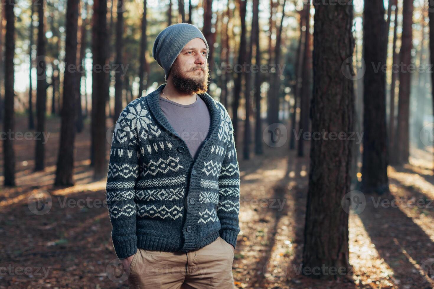 a young man with a beard walks in a pine forest. Portrait of a brutal bearded man Autumn forest photo