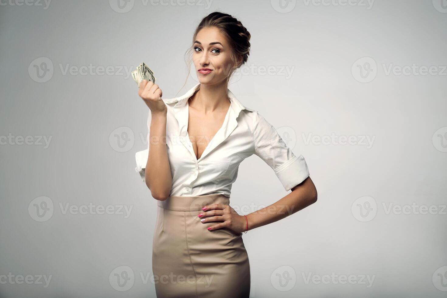 Beautiful elegant young bussines woman standing on the studio with gray background photo