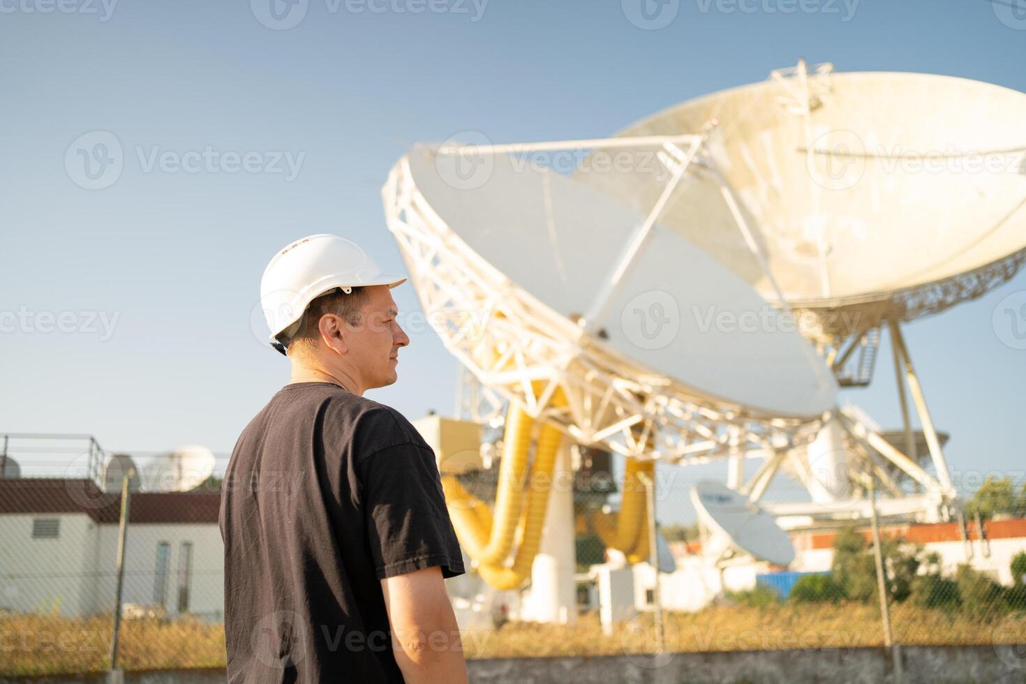 Engineer looking earth based astronomical radio telescope photo