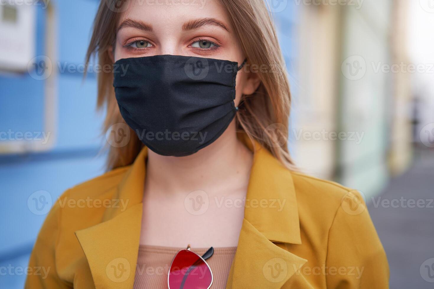 joven caucásico europeo niña 20 años antiguo vistiendo negro protector médico máscara proteccion en contra epidemia coronavirus covid-19 foto